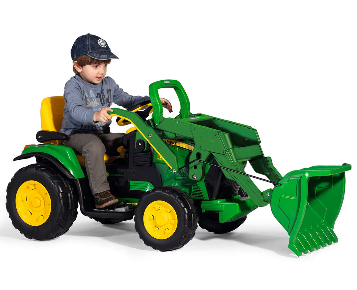 Das Elektrofahrzeug Peg Perego John Deere Gator Ground Loader aus unserem Babyfachmarkt, mit Kind das auf dem Traktor sitzt, gelb und grün, 12V